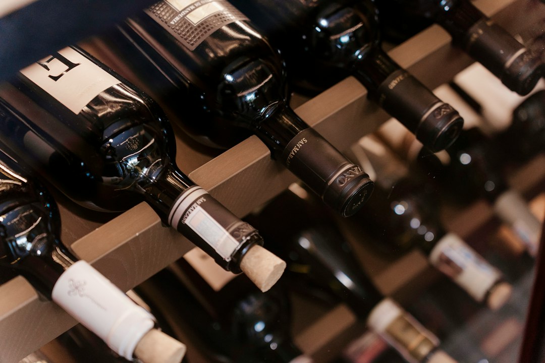 a-bunch-of-bottles-of-wine-sitting-on-a-shelf-qyqckev3kgk